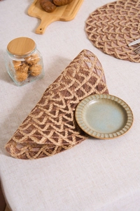 Detailed view of the woven hollow texture on a brown rustic round jute fiber placemat