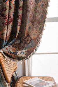 Detail of geometric jacquard fabric with white fringe tassels for curtains and home decor