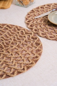 Detailed macro view of round woven table mat with intricate hollow geometric patterns