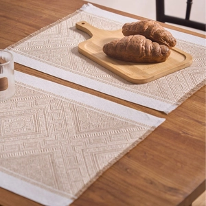 Bohemian jacquard woven placemats with geometric patterns and tassels on a wooden table