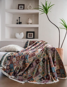 Detail of bohemian geometric jacquard throw blanket with decorative fringe tassels