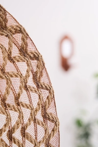 Close-up of natural jute rope woven placemat with intricate mesh texture and wave pattern