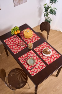 Top view of four red gingerbread man Christmas placemats on a rustic wooden table