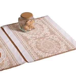 Nordic jacquard placemat with mandala patterns and fringe on a wooden table