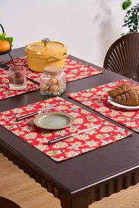 Detail of red Christmas gingerbread placemat texture on dark wooden dining table