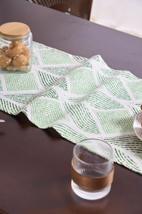 Close-up of green geometric diamond patterns on thick white cotton-linen table runner
