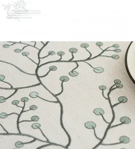 Close-up of premium cotton linen tablecloth with green floral embroidery and textured fabric