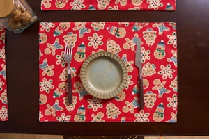 Detailed texture of red American vintage Christmas placemat with gingerbread man and snowman