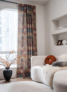 Detail of geometric diamond jacquard curtain fabric with white decorative tassels