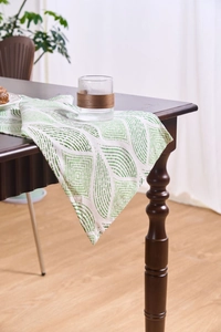 Detail of Nordic jacquard table runner with green geometric patterns and soft cotton texture
