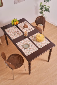 Detailed view of four heat-resistant Christmas placemats with gingerbread and tree patterns