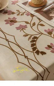 Detailed close-up of high-density floral embroidery on soft linen-textured tablecloth