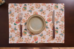 Detail shot of rectangular gingerbread man Christmas placemat on a wooden table