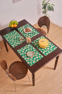 Detailed view of dark green placemats with Christmas gingerbread man and tree prints