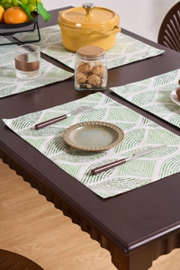 Detail of green geometric leaf pattern on cotton linen placemat set for dining table