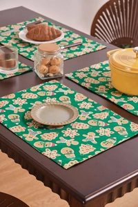 Close-up of festive Christmas placemats with gingerbread man and tree patterns