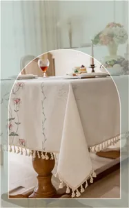 Detail of floral embroidery and cream tassels on high-quality linen tablecloth