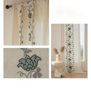 Detailed embroidery of grey roses and decorative tassel trim on cream curtains