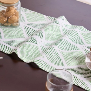 Nordic yellow geometric jacquard table runner with tassels on a dark wood table
