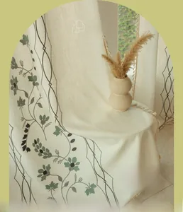 Detail view of American floral embroidery and fringe tassels on beige semi-sheer curtains