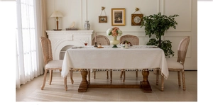 Close-up of cream rectangular tablecloth featuring textured fabric and delicate fringe tassels
