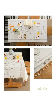 Detail of floral vine embroidery and handmade tassels on beige linen tablecloth