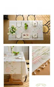 Close-up of pink peony embroidery and fringe tassels on a linen rectangular tablecloth