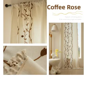 Detail of French vintage curtains featuring brown rose embroidery and tassels on linen fabric