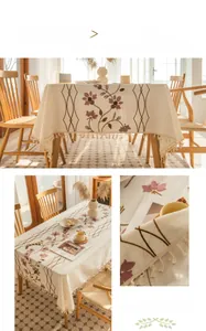 Close-up of cream tablecloth with purple vine embroidery and elegant fringe edges