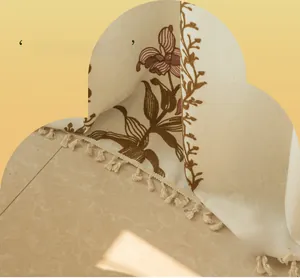 Dettaglio tenda in cotone lino beige con motivi floreali vintage e bordi con nappine