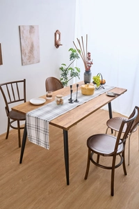 Modern Nordic style white and grey plaid fabric table runner displayed on wooden dining table.