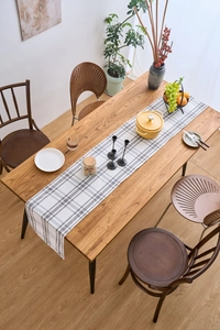 Top-down view of a grey and white checkered table runner on a dark wood table