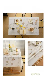 Detail of cream fabric tablecloth featuring elegant vine embroidery and tassel fringe edges