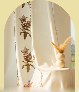 Dettaglio di tenda beige vintage con eleganti ricami floreali viola e tessuto lino