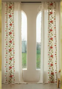Detail of red floral embroidery and beige tassels on cotton linen curtains for windows