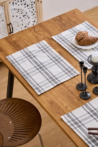Close-up of gray and coffee plaid placemat made of textured linen on a wooden table