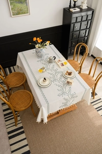 Detailed view of rectangle tablecloth with blue floral prints and handmade tassels