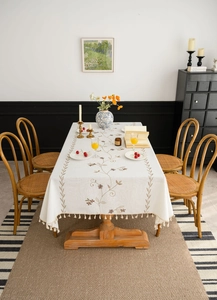 Close-up of floral embroidery and beige tassel edge on premium cotton linen tablecloth