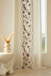 Detail of bohemian semi-sheer beige curtain with flower embroidery and fringe edge