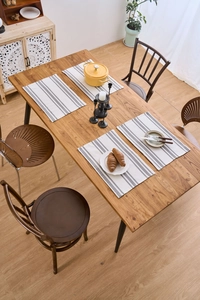 Top view of Nordic grey and white checkered fabric placemats on a natural wooden table