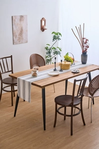 Close-up of modern rectangular dining table with natural wood grain and black metal legs