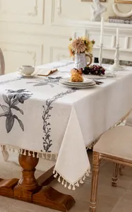 Broderie détaillée de motifs floraux gris et glands sur nappe en coton et lin beige