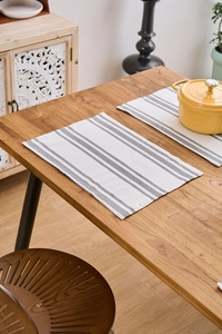 Detail of grey striped heat resistant placemats set of 2 on a wooden dining table