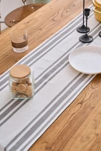 Close-up of minimalist white and grey striped table runner on a natural wood surface