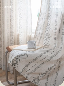 Detail of bohemian geometric black diamond pattern on cream linen kitchen curtain fabric