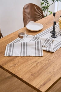 Macro shot of modern grey and white striped linen table runner on a wooden table