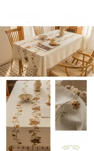 Macro detail of floral embroidery and fringe tassels on a vintage cotton linen tablecloth