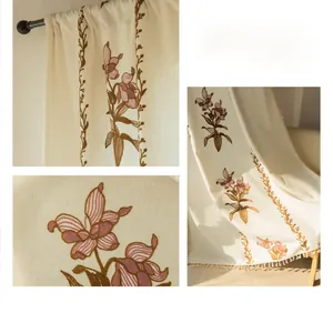 Dettaglio ricamo gigli viola su tende beige semitrasparenti con nappe eleganti