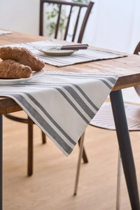 Detailed view of Nordic style grey and white checkered fabric placemat on a wooden table