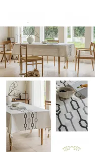 Detail of embroidered geometric pattern and tassel fringe on beige linen tablecloth